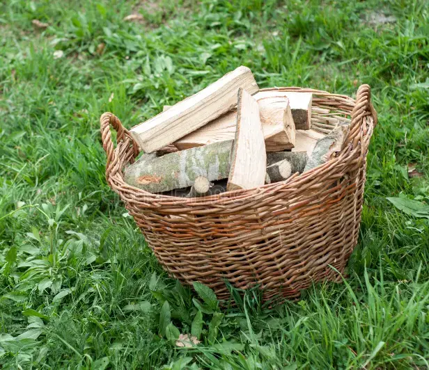 Mand met haardhout voor vuurplaats op De Nix Hoeve